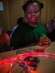 Une petite fille regarde les led rouges allumées d'un système électrique