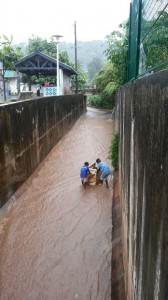 Des enfants jouent avec un frigo abandonné dans un collecteur d'eaux pluviales à Kawéni