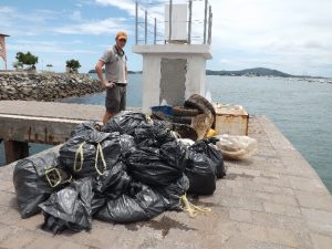 Johannes Chambon, médiateur environnement aux Naturalistes, devant les déchets ramenés des fonds de Mbouzi