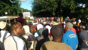 Les manifestants et les passant se massent sur le barrage pour écouter les résultats de la réunion