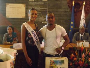 Fahdedine reçoit des mains de Miss Mayotte une partie des équipements pour de la délégation de l'athlétisme