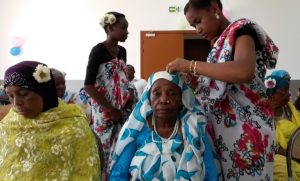 Les jeunes filles fleurissent les grands-mères lors d'une opération mêlant les génération à Tsingoni en janvier 2016
