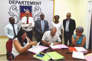 Ida NEL, Gérante de la MCG, Gilles LANGLOIS et Arlette HENRY de la SMART ratifiant les contrats de partenariat sous les regards de Seymour MORSY, Soibahadine IBRAHIM RAMADANI Président du Conseil départemental, Fatima SOUFFOU 1ère Vice-Présidente, Bourhane ALLAOUI Président du Conseil portuaire et Jean-Pierre SALINIERE DGS du Département.