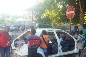 Une carcasse de voiture à la sortie des enfants de l'école élémentaire Passamainty Village 1